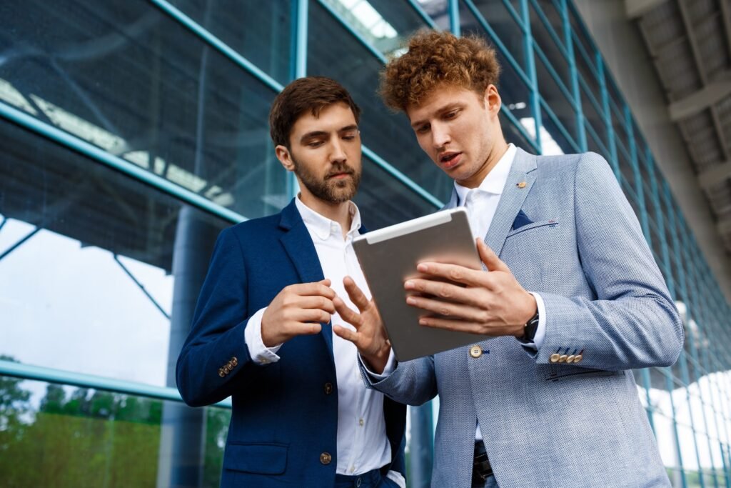 Dois homens olhando para um tablet, líder